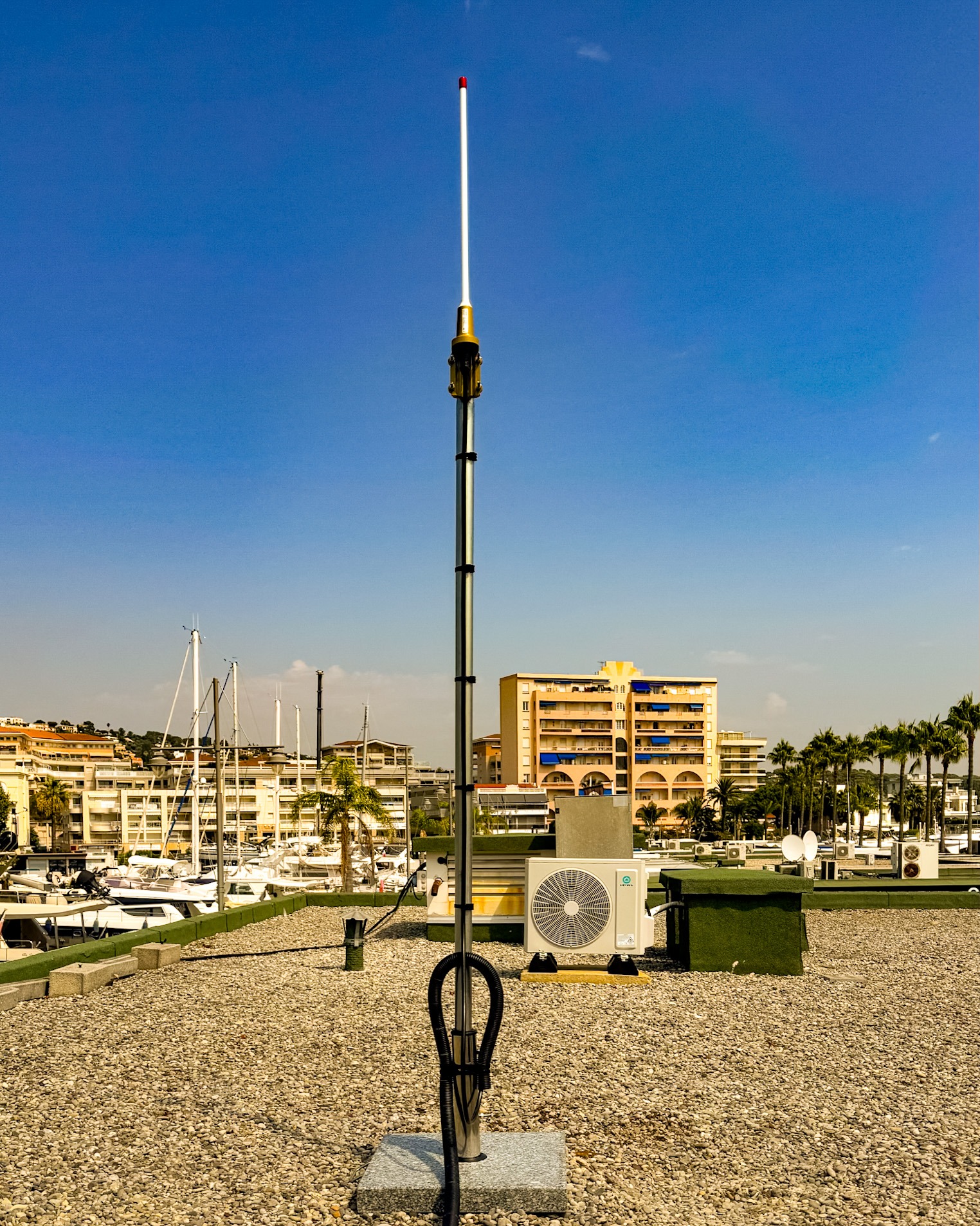 Antenne radio professionnelle Poly-Com installée sur un toit-terrasse face au port